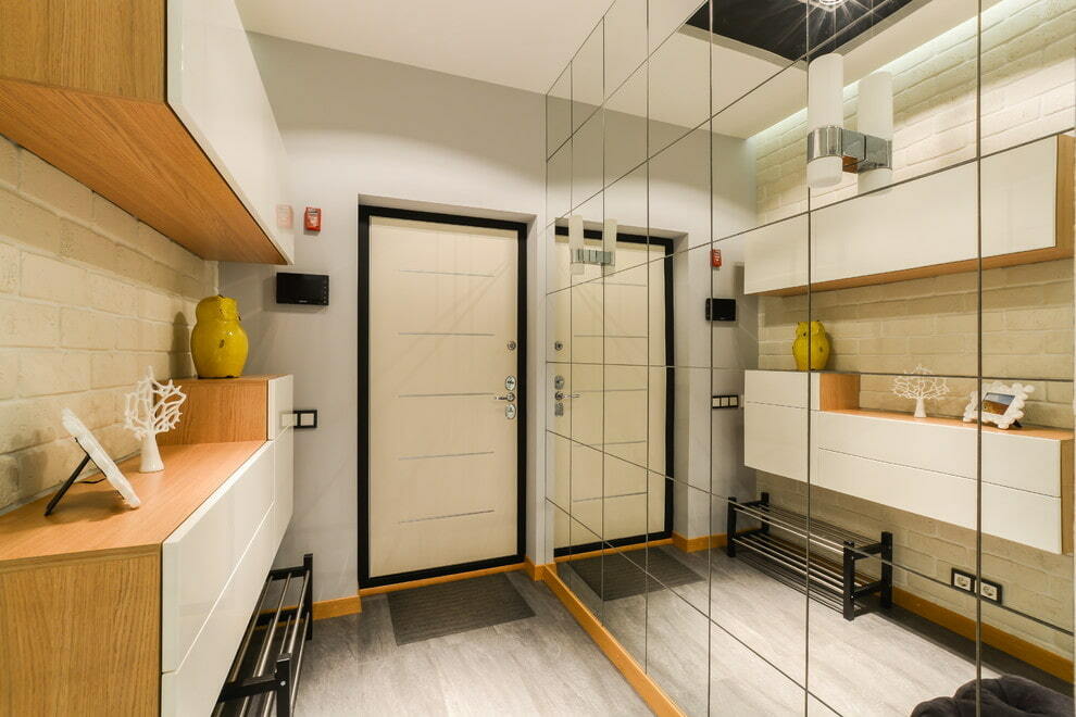 Móveis modulares no corredor com parede espelhada
