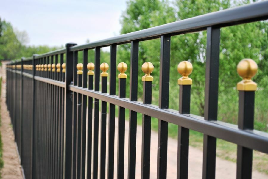 Şekillendirilmiş borulardan yapılmış bir çit üzerinde altın dekor