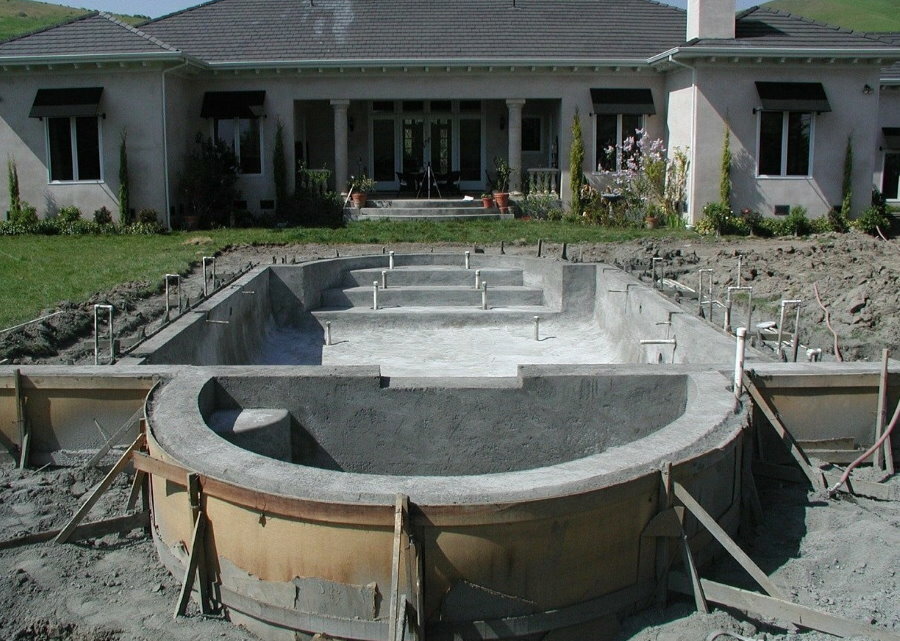 Construção de piscina de concreto em área suburbana