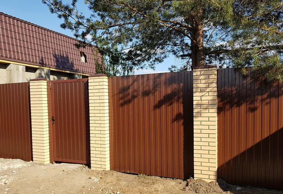 Contrast corrugated fence on brick supports