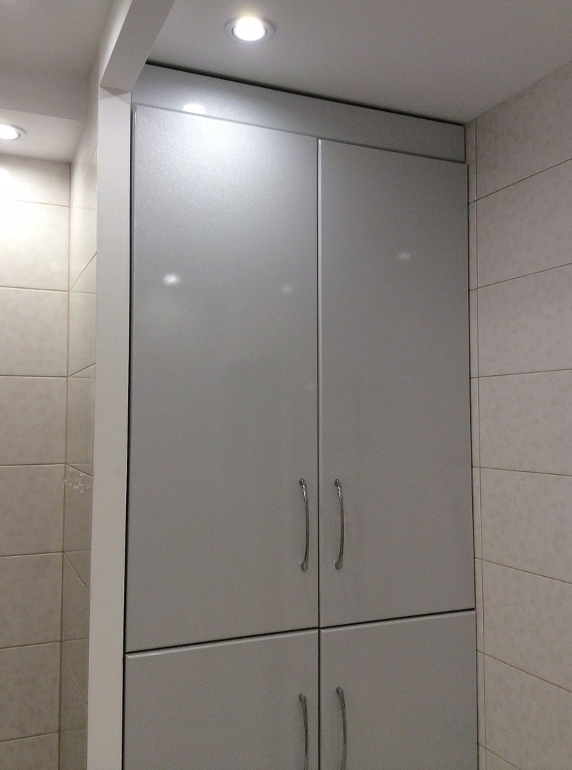 Grå indbygget garderobe i et lille badeværelse
