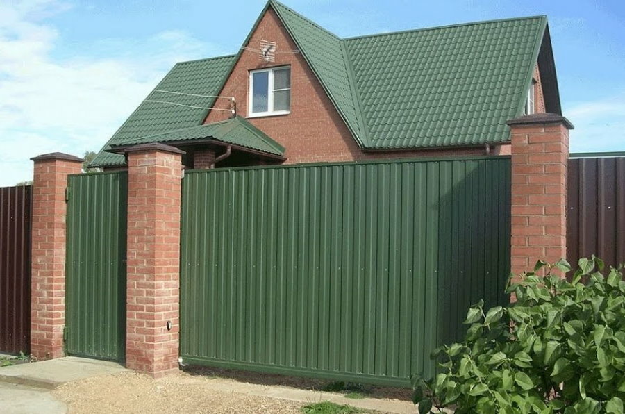 Green trapezoidal sheet on the gate under the roof on the house