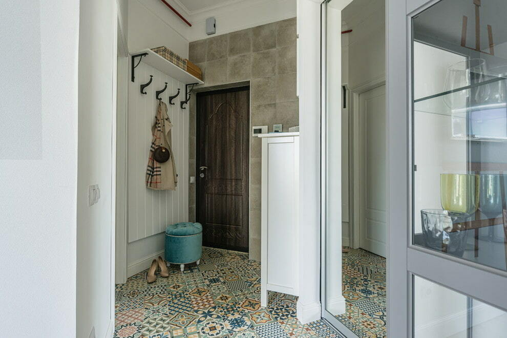Oregelbundet formade keramiska plattor på golvet i korridoren