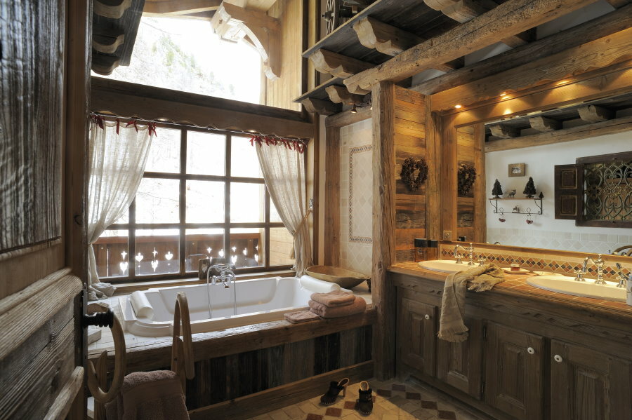 Banheira de acrílico em frente à janela de uma casa de madeira