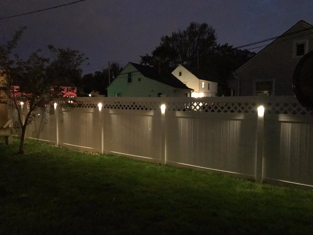 Iluminação noturna de uma cerca campestre de madeira