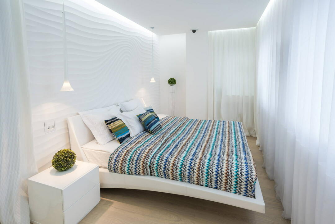 Kylančios lubos miegamajame su baltomis užuolaidomis