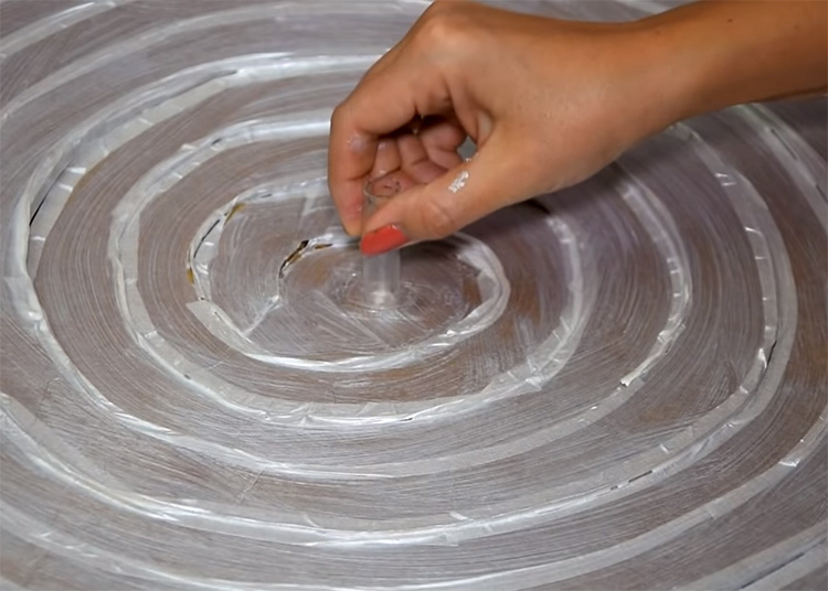 Påfør lim og fest sprøyten i midten av spiralen med den skarpe enden i papp. For mer pålitelighet av tilkoblingen, kan du helle varmt lim rundt kantene på sprøyten
