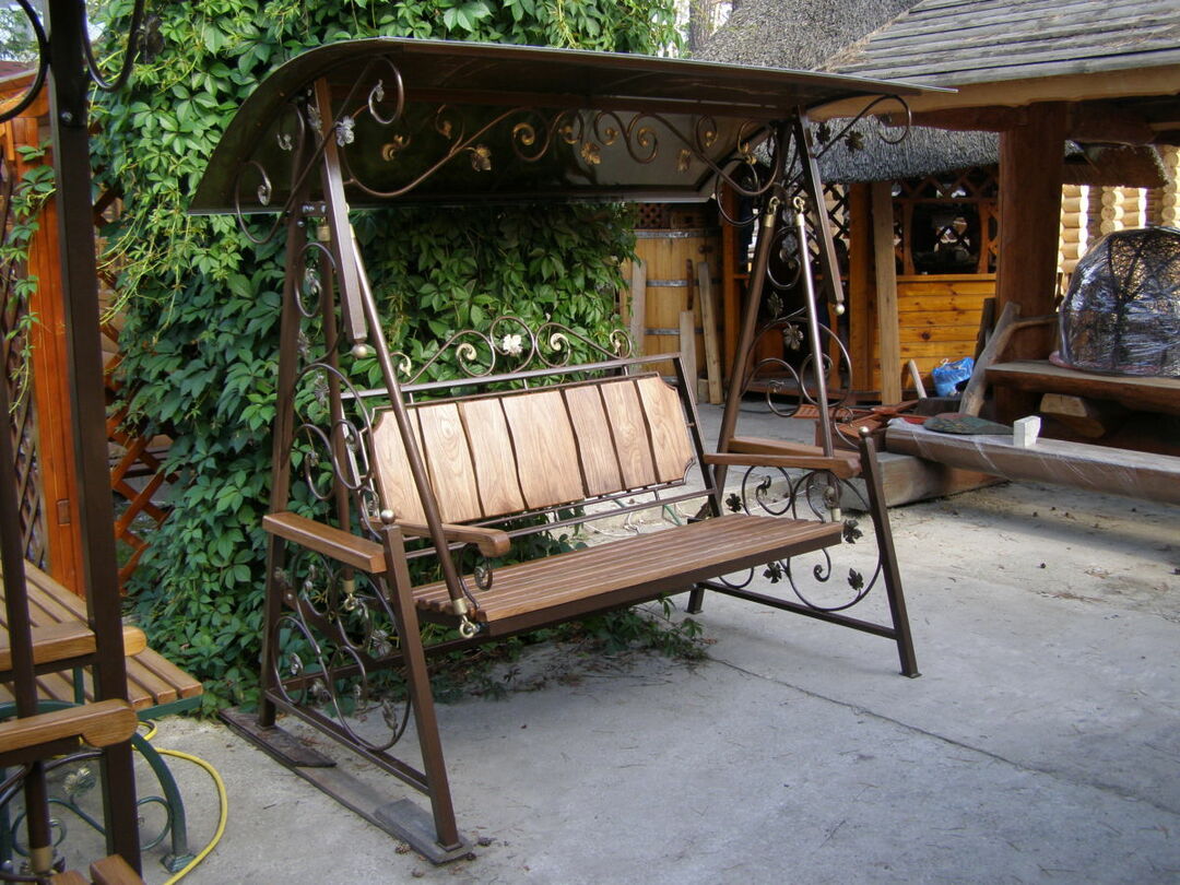 Garden swing with a canopy: forged from metal, shaped pipe and wood