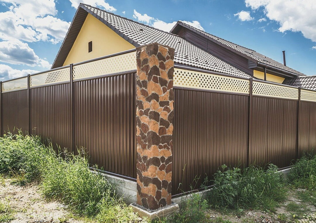 Ein Zaun aus Ziegeln und Wellpappe: ein Foto von einem schönen Design mit Ziegelpfeilern