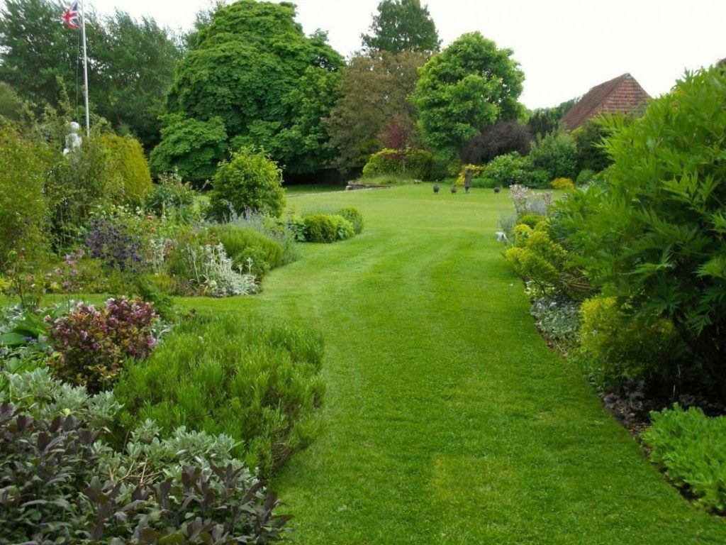 Vihreä nurmikko maisema -tyylisessä puutarhassa