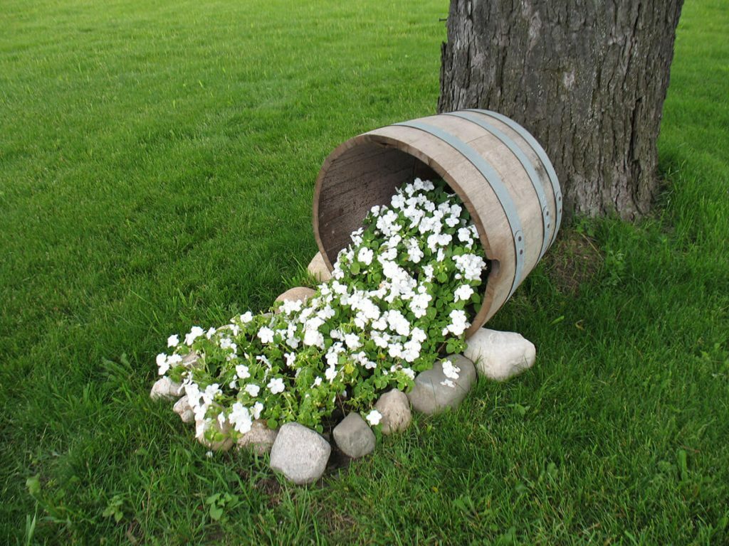 Blumenbeet-Stream aus einem Holzkübel
