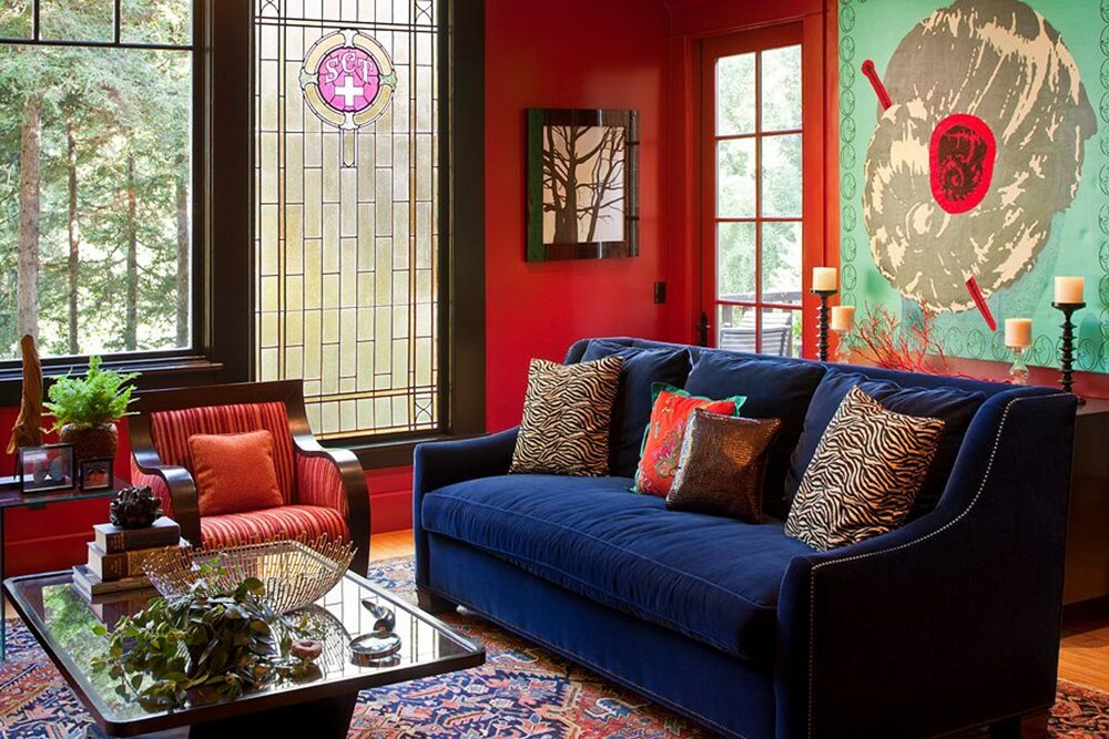 Blå soffa i vardagsrummet med röda väggar