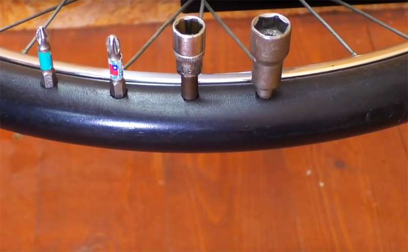 Faites de petits trous dans le tuyau en plastique qui remplace le pneu avec une perceuse: vous pouvez y ranger des perceuses et des embouts
