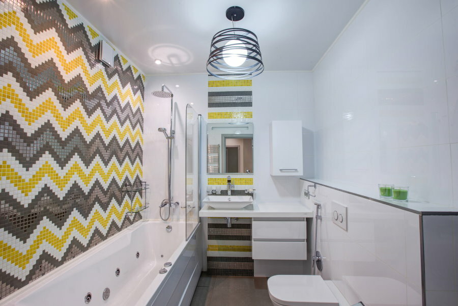 Harmaa-keltainen mosaiikki kylpyhuoneen seinällä, jonka pinta-ala on 5 5 neliötä