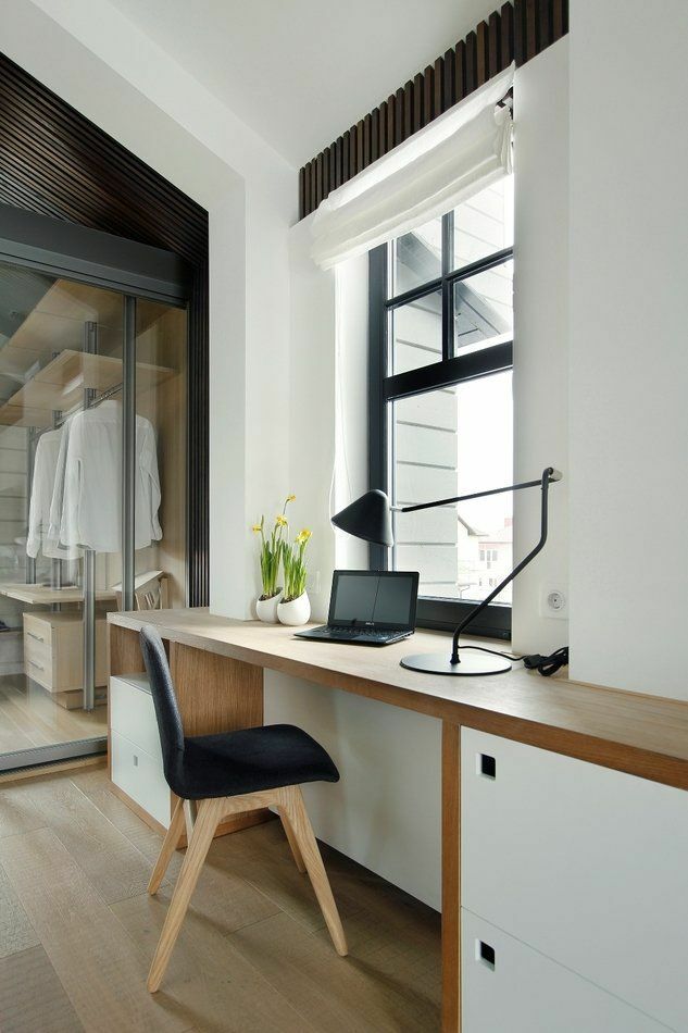 Piano di lavoro in legno di fronte a una finestra della stanza in stile scandinavo