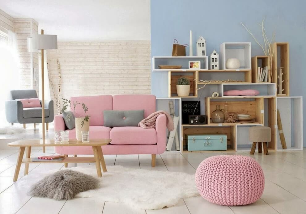 Lyserød sofa i et værelse med en blå væg