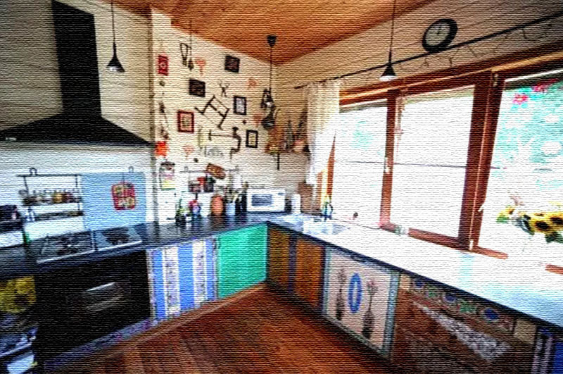 Una pared está colgada con utensilios de cocina antiguos y cuadros bordados.