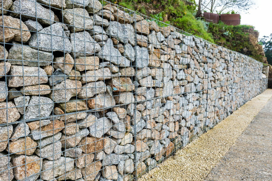 Dövs staket av gabioner med stenfyllning