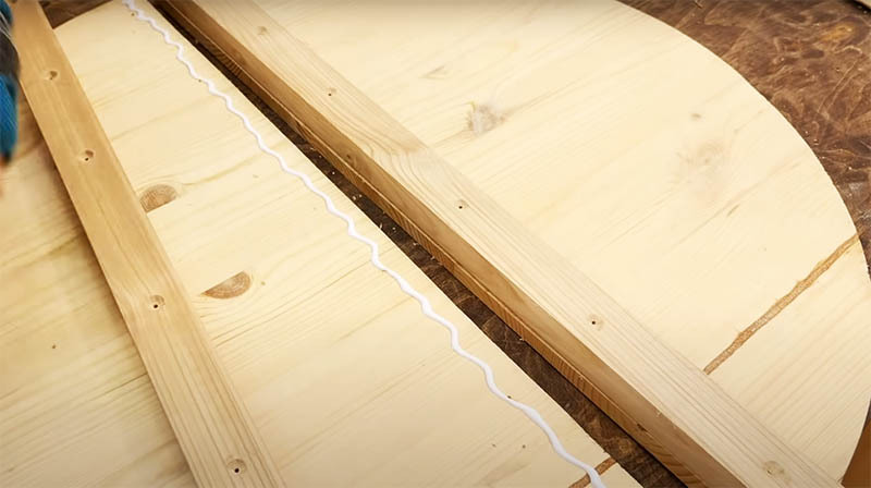 Die Verbindung der beiden Tischhälften von der Unterseite wird auf zwei Holzstücken befestigt. Montieren Sie die Befestigungselemente von der Seite des Holzes so, dass sie auf dem " vorderen" Teil der Tischplatte unsichtbar sind. Vergessen Sie nicht, Löcher für selbstschneidende Schrauben vorzubohren, damit das Holz während des Betriebs nicht reißt, und versenken Sie, um die Kappe zu ertrinken