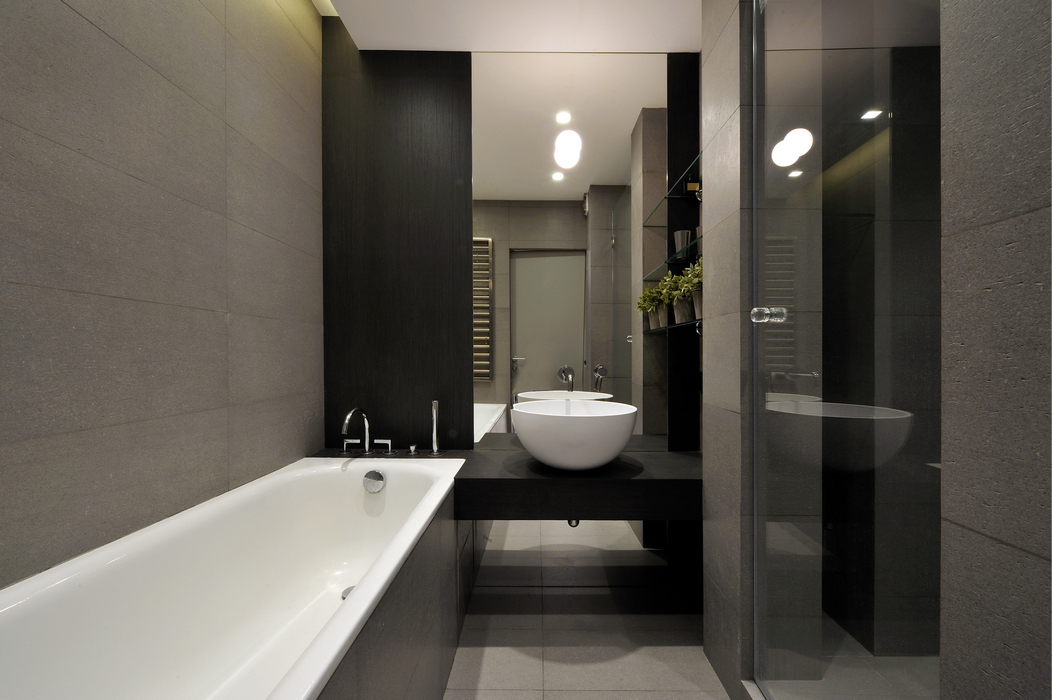 Sivo porculansko kameno posuđe na zidu male kupaonice