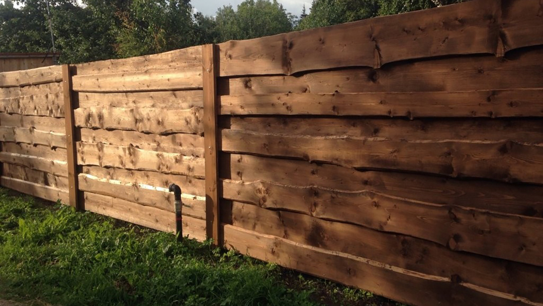 A fence made of boards: vertical and horizontal, of the edging and edging board