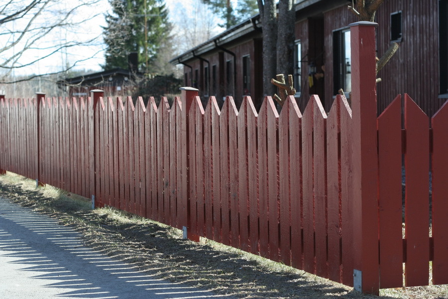 Painted fence made of wooden boards at their summer cottage