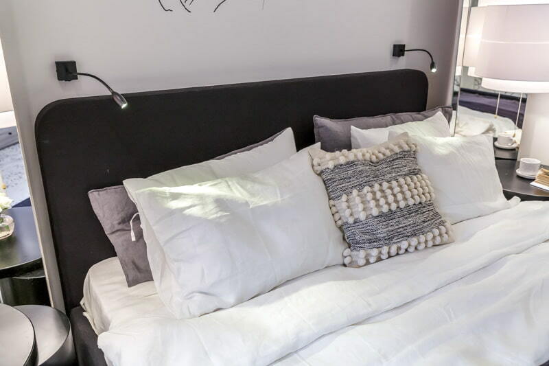 Modern lámpák egy széles ágy fejtámlája felett
