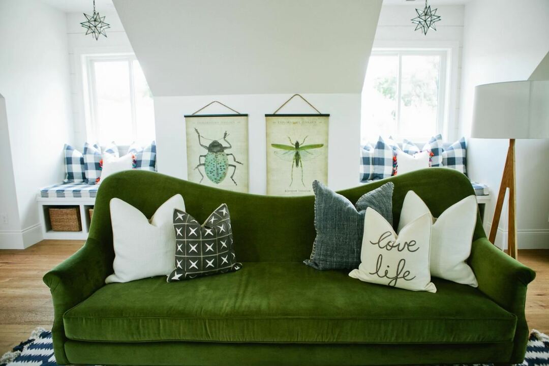 Zaļš dīvāns mansarda istabas interjerā