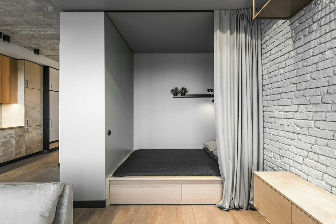 Podium met een bed in een nismuur van een studio appartement