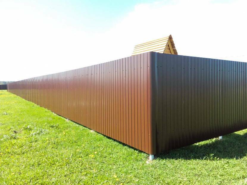 Jednoduchý plot z profilovaného plechu po obvode chaty