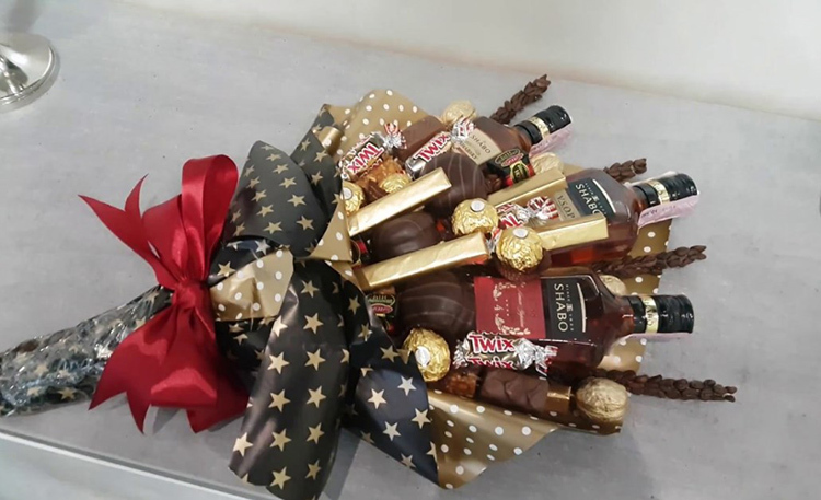 C'est aussi un bouquet, mais regardez combien il est brutal: mini-bouteilles de collection avec un bon cognac, chocolat et café ont été utilisés pour la décoration