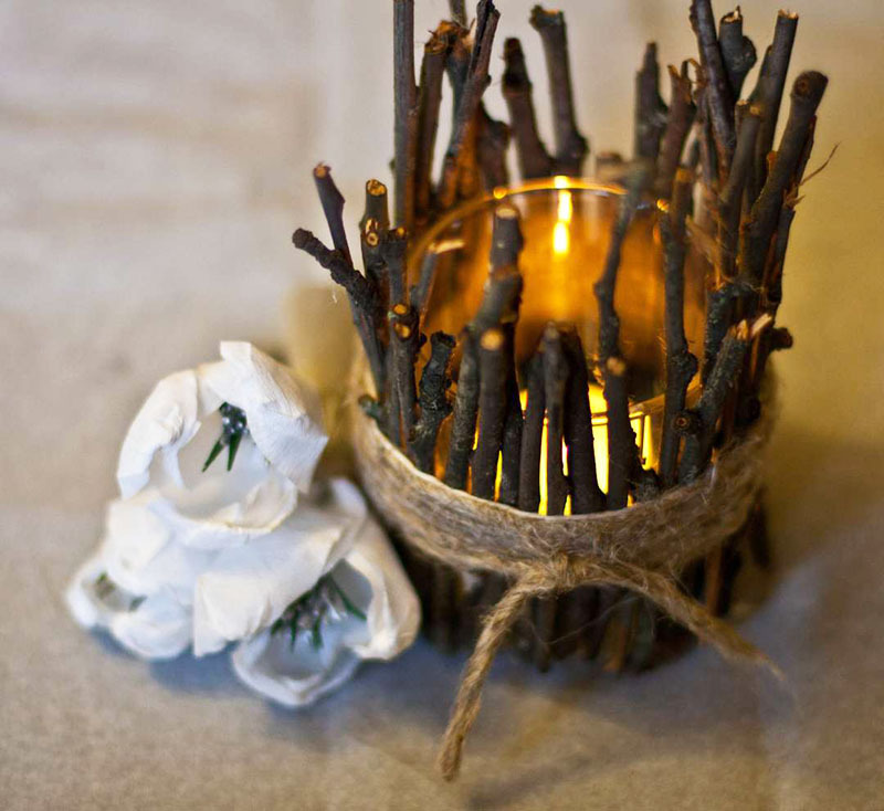 Kynttilänjalat juhlatilaan voidaan valmistaa tavallisista oksista. Leikkaa ne tikuiksi ja aseta lasin halkaisijaan
