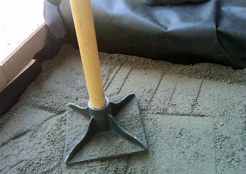 Após o enchimento, a almofada de areia e cascalho é derramada com água de um regador e compactada