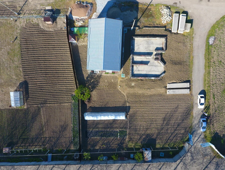 Vista superior de uma área suburbana com uma horta e uma casa