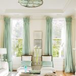 Parede cornijas com cortinas azul-turquesa na sala de estar