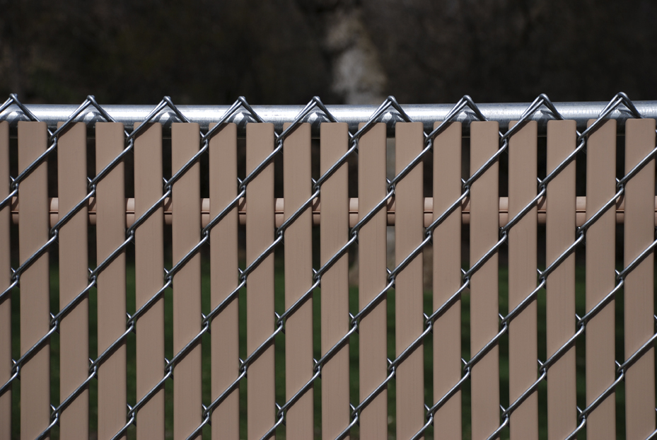 Decorating a fence made of a chain-link mesh with polymer tape
