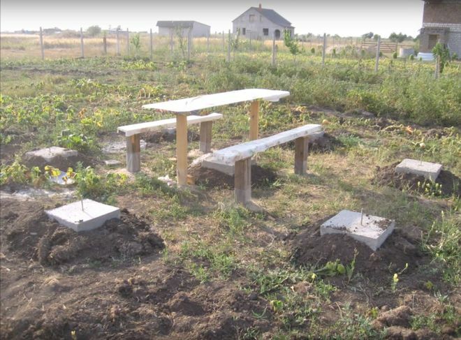 Zelfgemaakte betonnen steunen voor een houten tuinhuisje