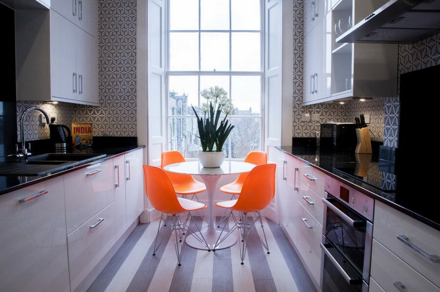 Oranžové stoličky v úzkej paralelný kuchýň