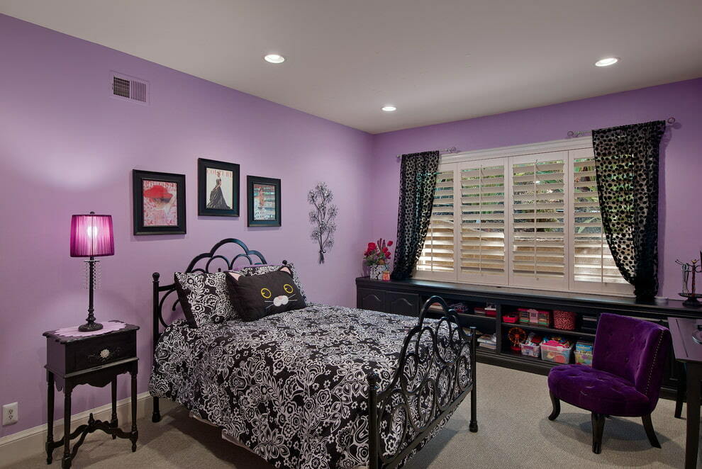 Mustat huonekalut makuuhuoneessa violetilla tapetilla