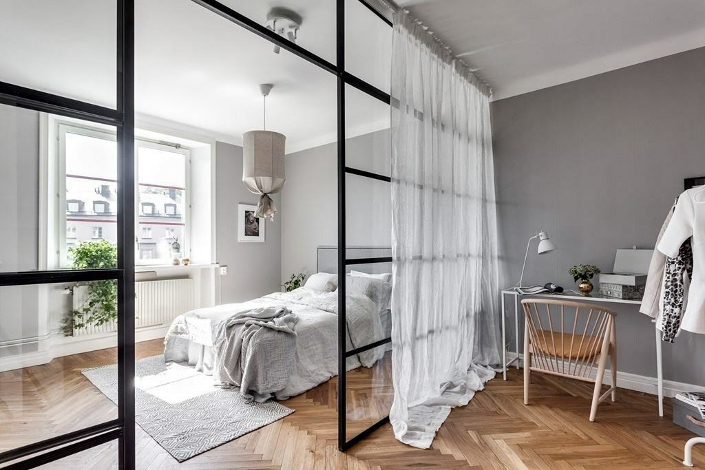 Seng bag en skillevæg i et enkelt værelse i skandinavisk stil