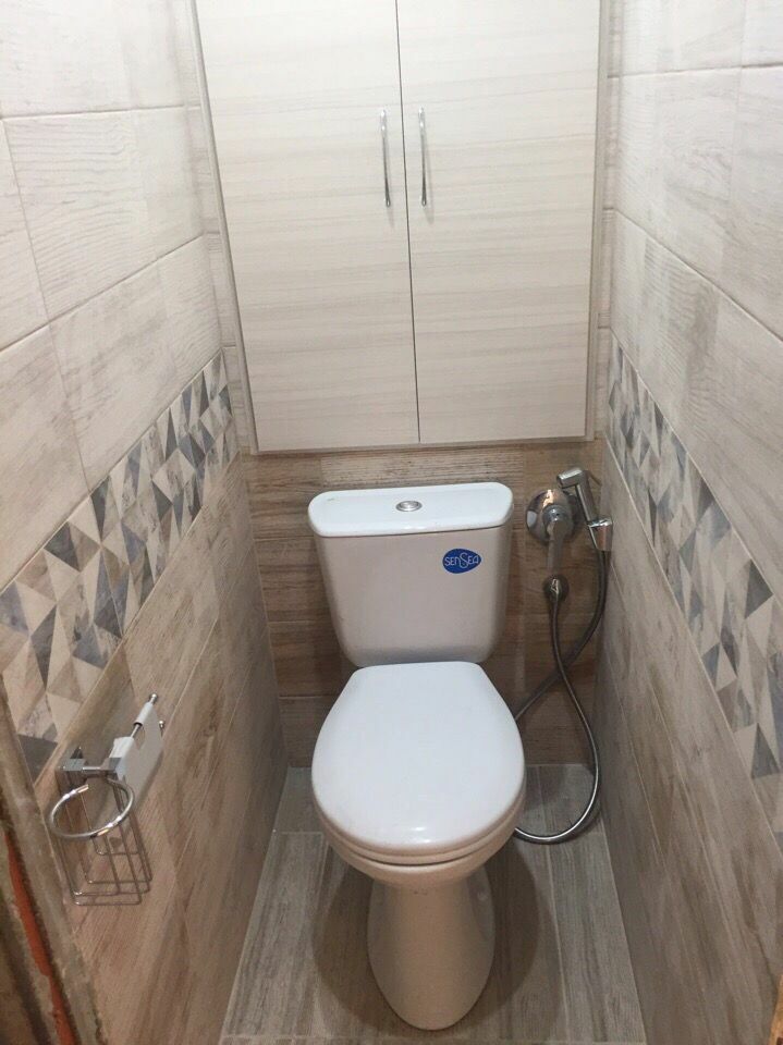 Szekrény háztartási szükségletekhez a WC mögött egy keskeny WC -ben