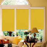 Yellow curtains roll type arched window