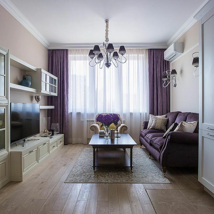 Malý obývací pokoj s fialovou pohovkou u zdi