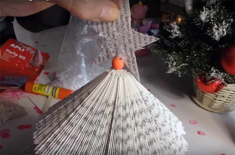 The decoration is simply attached to the book tree with ordinary glue. A drop in the very center - and install