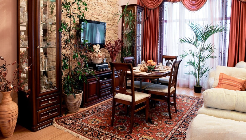 Jarrones de piso de cerámica con composiciones de flores secas y macetas con plantas vivas complementan la decoración.