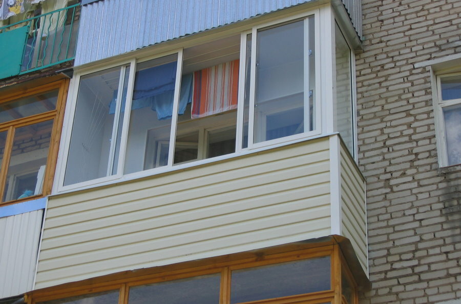 Ommanteling met PVC-beplating van een balkon op een bakstenen hoogbouw