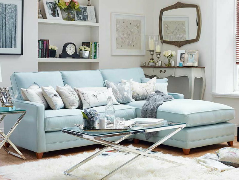 Gaiši zils dīvāns privātmājas dzīvojamā istabā