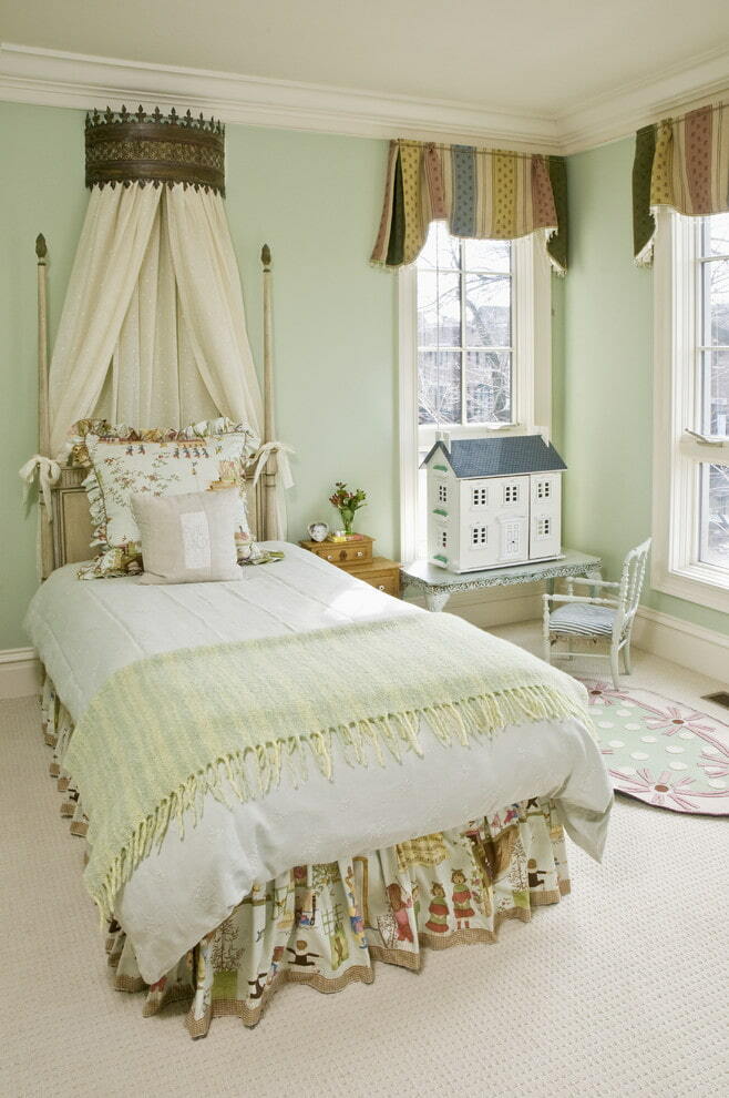 Habitación de niña con un hermoso dosel sobre la cama.
