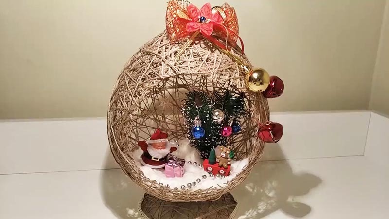 Také dovnitř jsme vložili improvizovaný miniaturní vánoční strom s kuličkami, figurkou Santa Clause, dárky a vánočními korálky