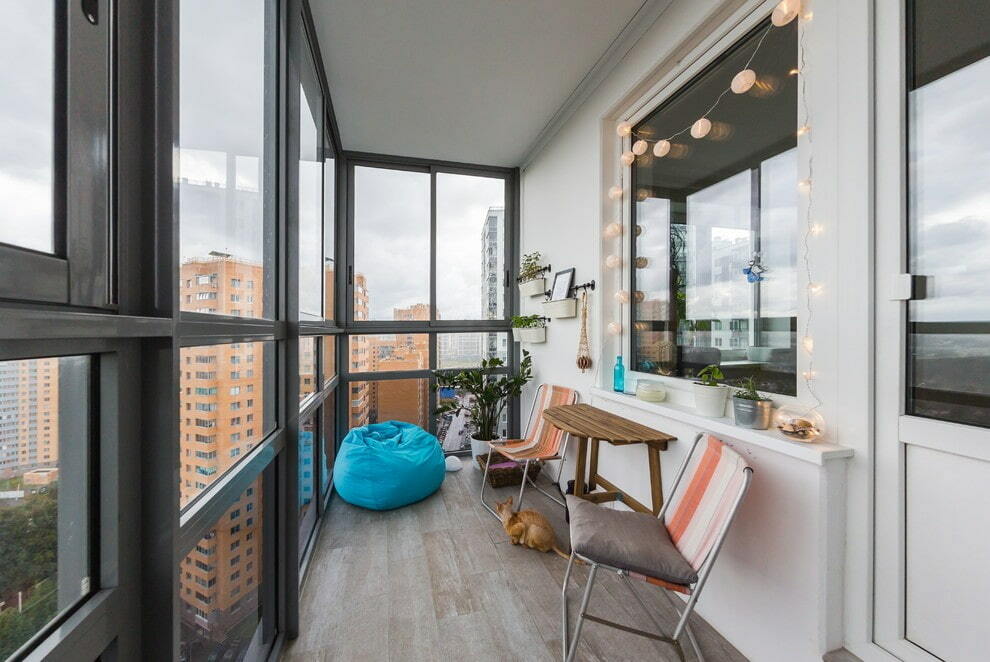 Pludmales krēsli uz balkona ar panorāmas logiem